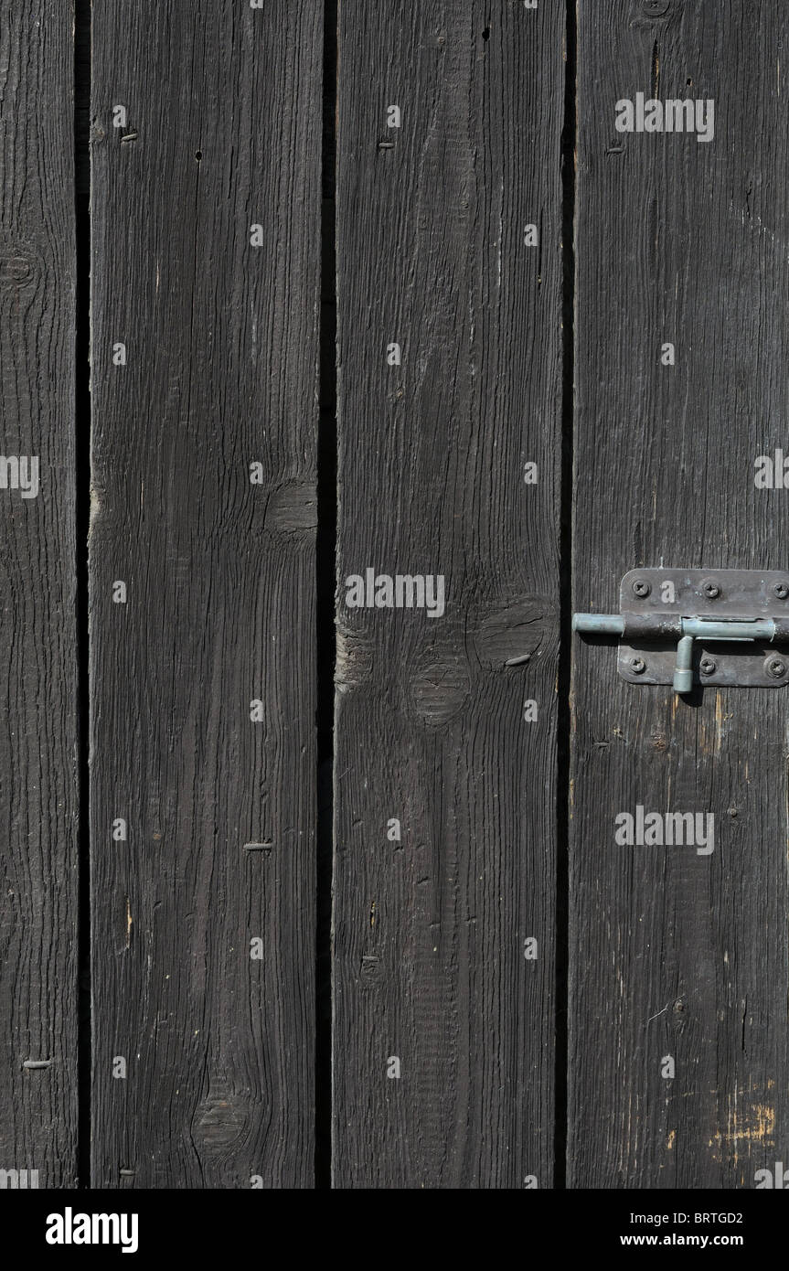 Old shabby wooden wall with a bolt. Stock Photo