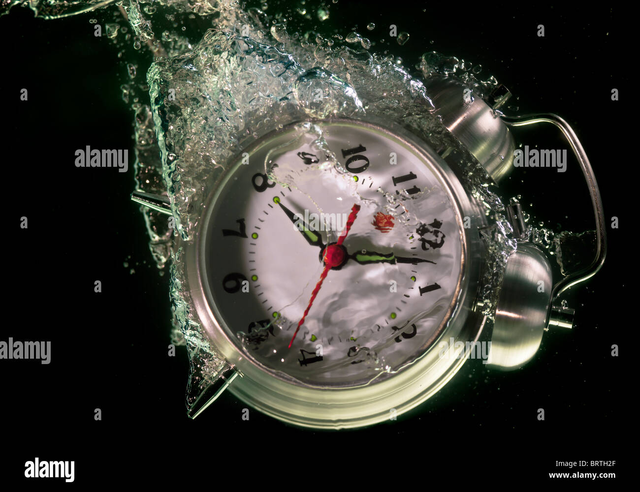 Alarm clock sinks underwater Stock Photo