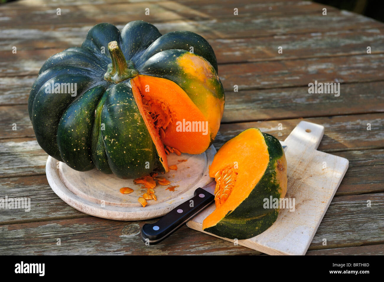 Green pumpkin on a wooden board. Stock Photo