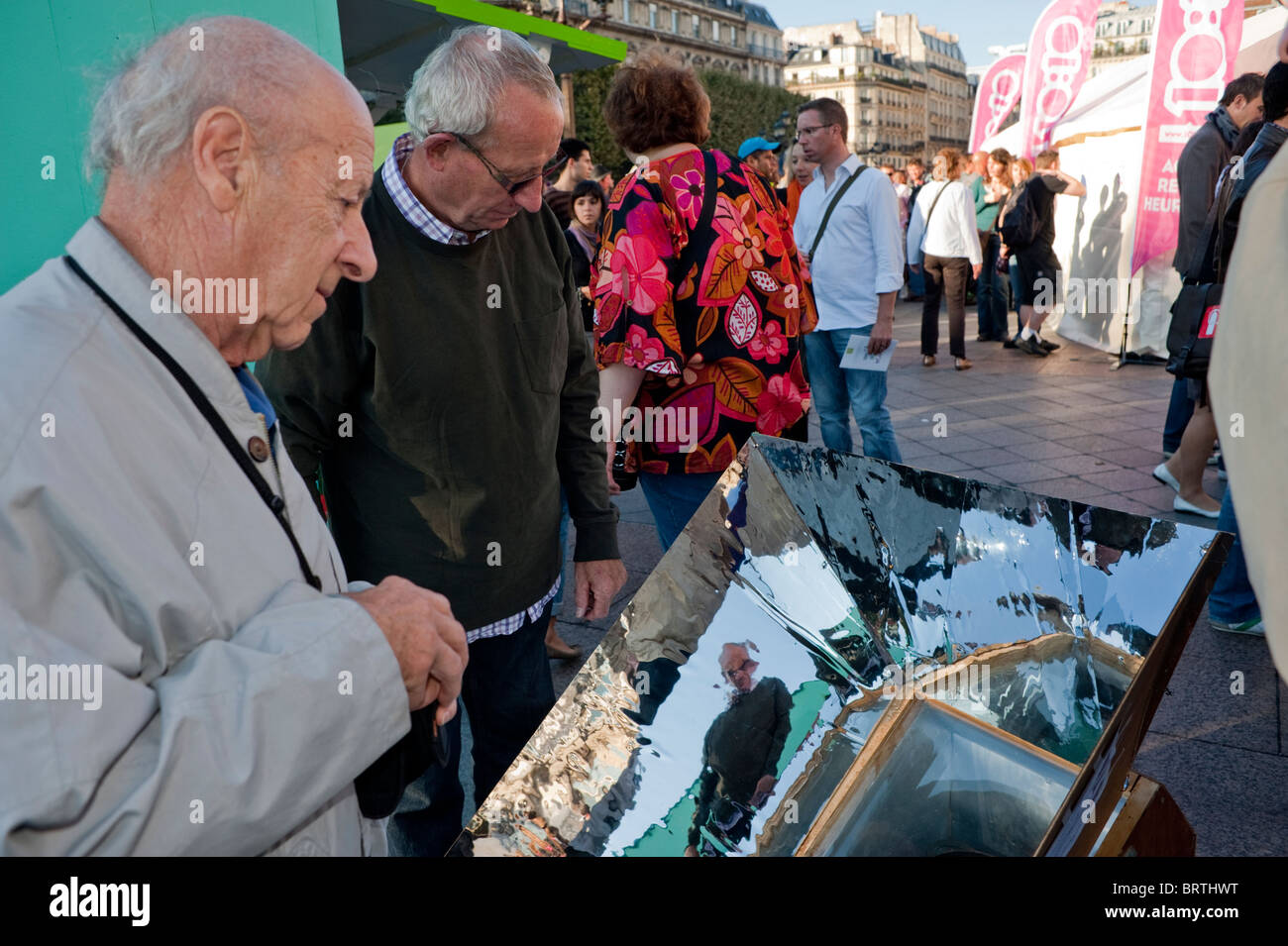Paris, France - Exterior, Environmental Awareness Day, Senior Man Explaining Solar Oven Cooking to Public, scientists sharing Stock Photo