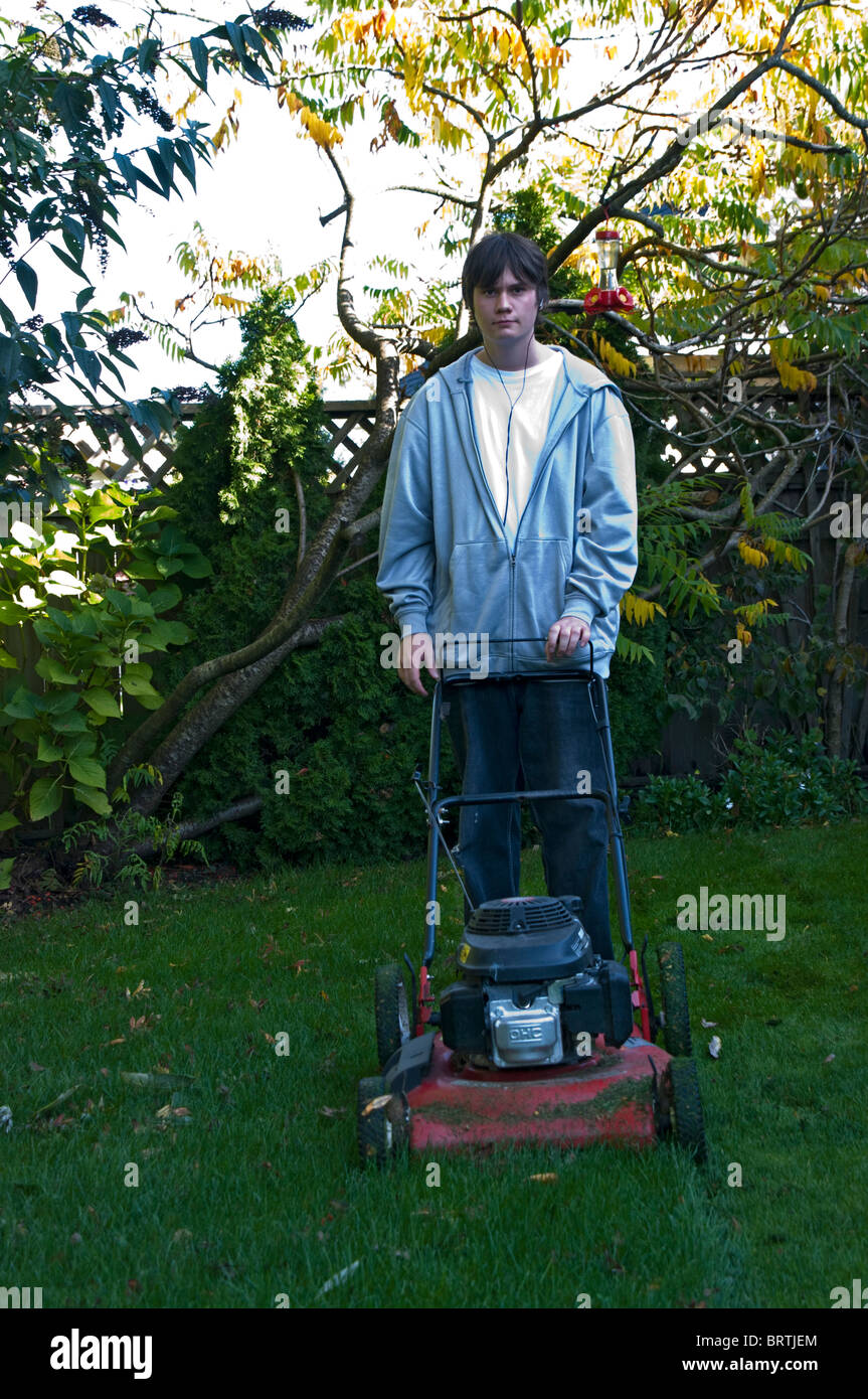 Teenager cutting lawn Stock Photo