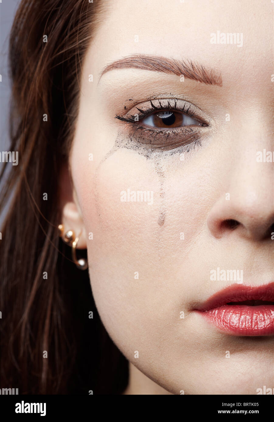 closeup portrait of beautiful crying girl with smeared mascara Stock