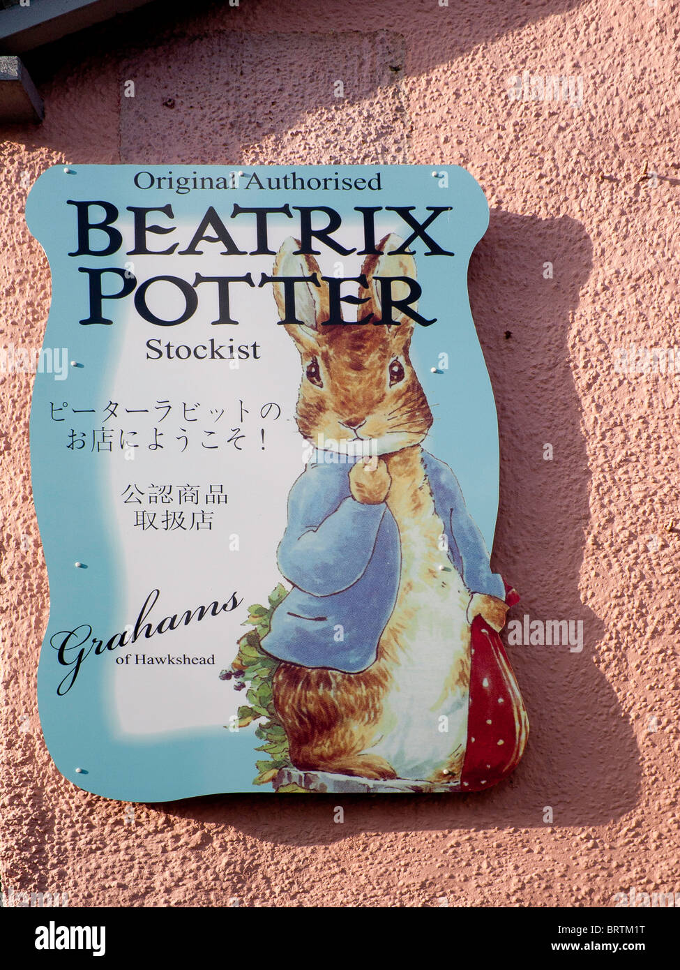 A sign for a shop selling Beatrix Potter branded items in the English Lake District sign in Japanese and Chinese script Stock Photo