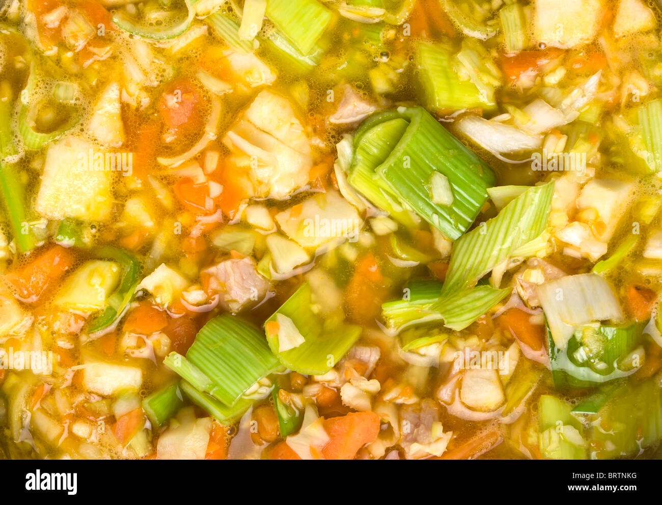 Vibrant Rustic vegetable and ham broth background or texture. Stock Photo