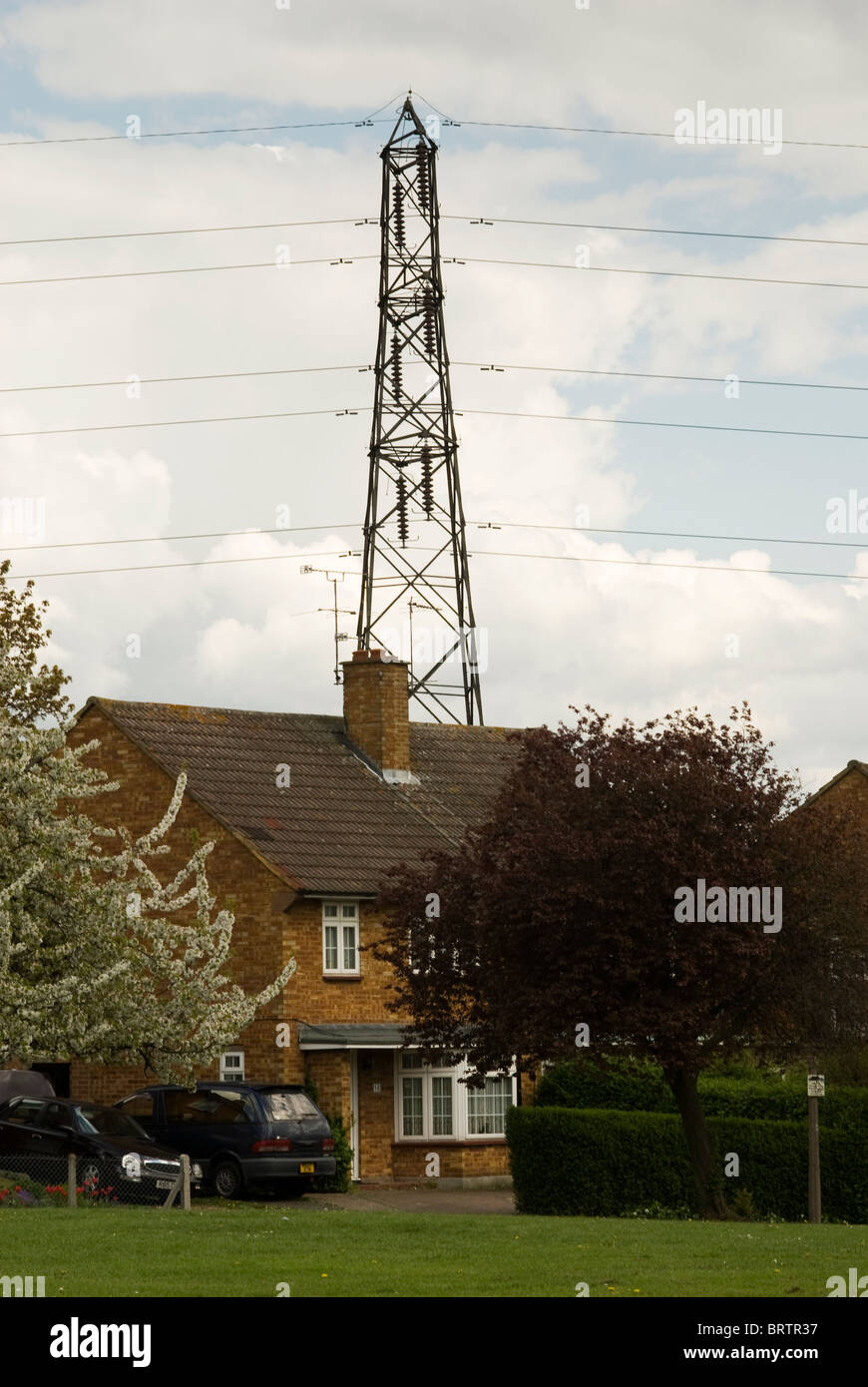 Electricity pylon in close proximity to a domestic house Stock Photo