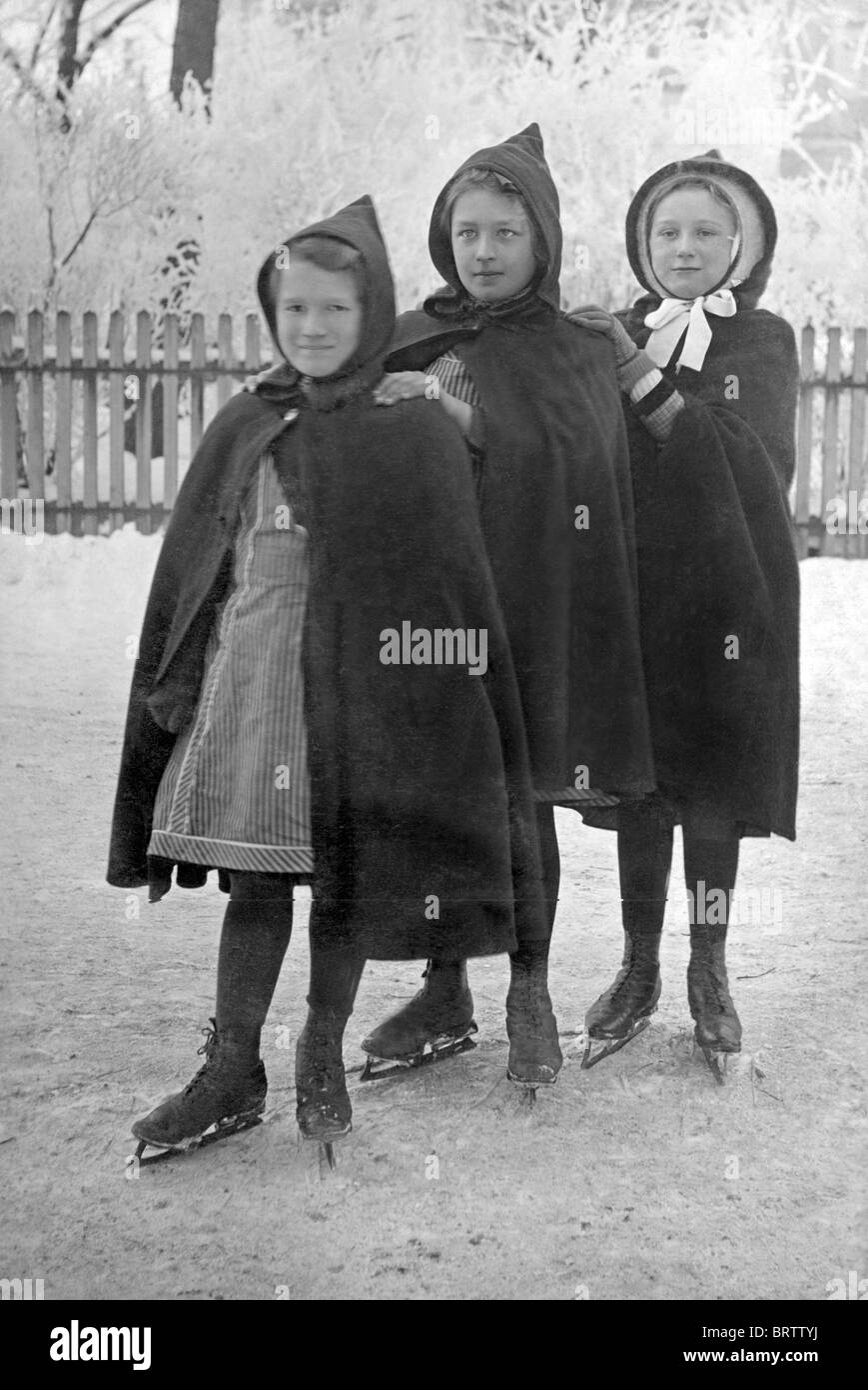 Three girls wearing ice skates, historical image, ca. 1915 Stock Photo
