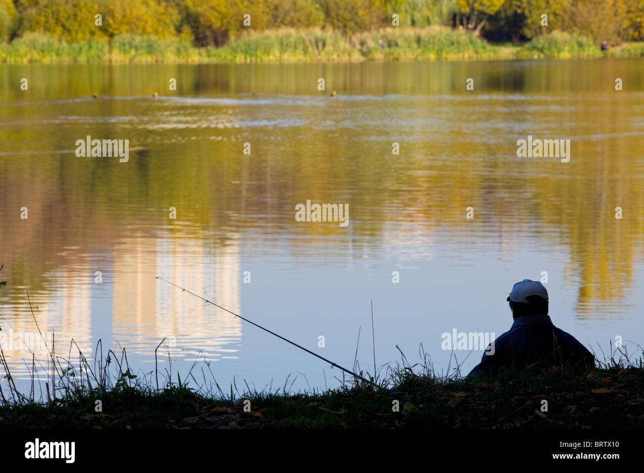 fisherman silhouette near pond at sunset Stock Photo - Alamy