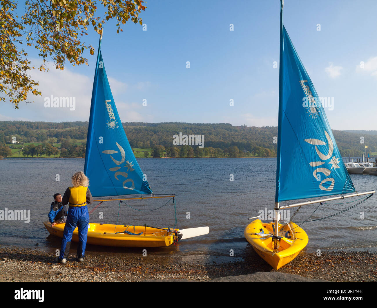 A teenage boy and a woman discuss sailing experience on Coniston Water Cumbria England Stock