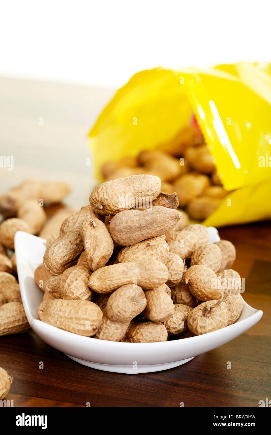 Peanuts in front of a bag of peanuts Stock Photo