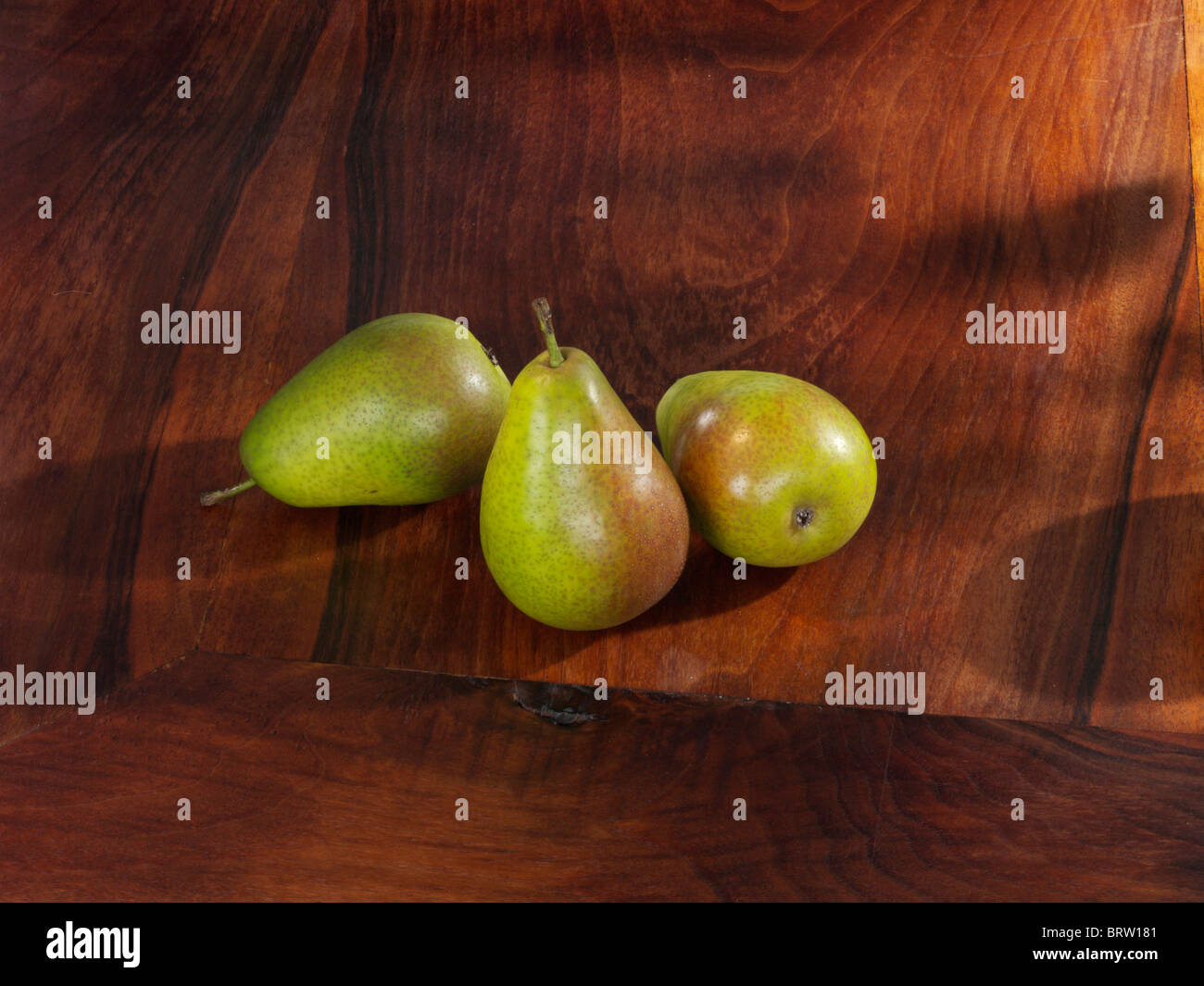 Three European Pears (Pyrus communis) on a wooden board, Gute Luise cultivar Stock Photo