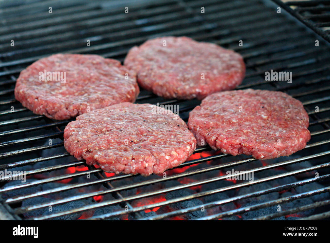 Hamburger patties cooking on a grill Stock Photo Alamy