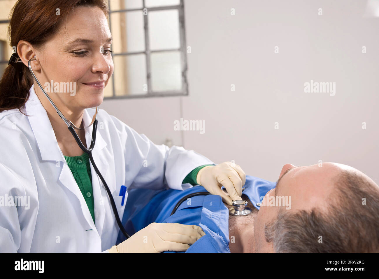 Female doctor using a stethoscope for auscultating a patient Stock ...
