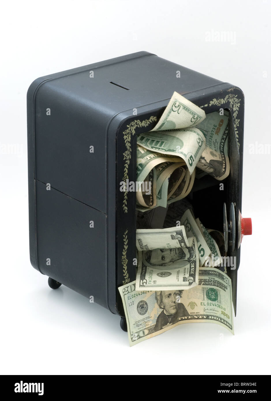 Money falling out of favor. USA dollars or American paper money tumbling from old toy bank safe with open door . Stock Photo