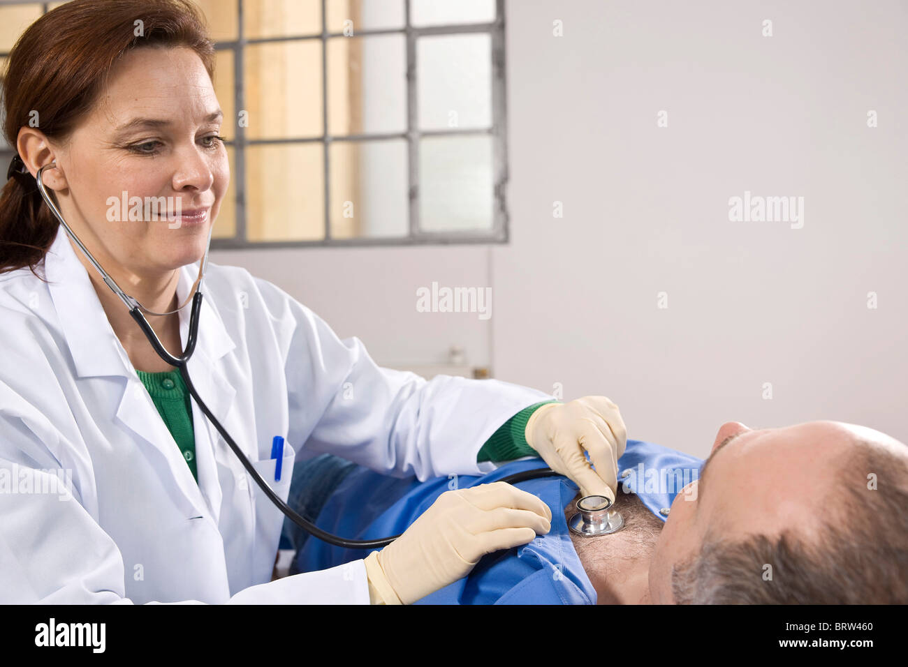 Female doctor using a stethoscope for auscultating a patient Stock ...