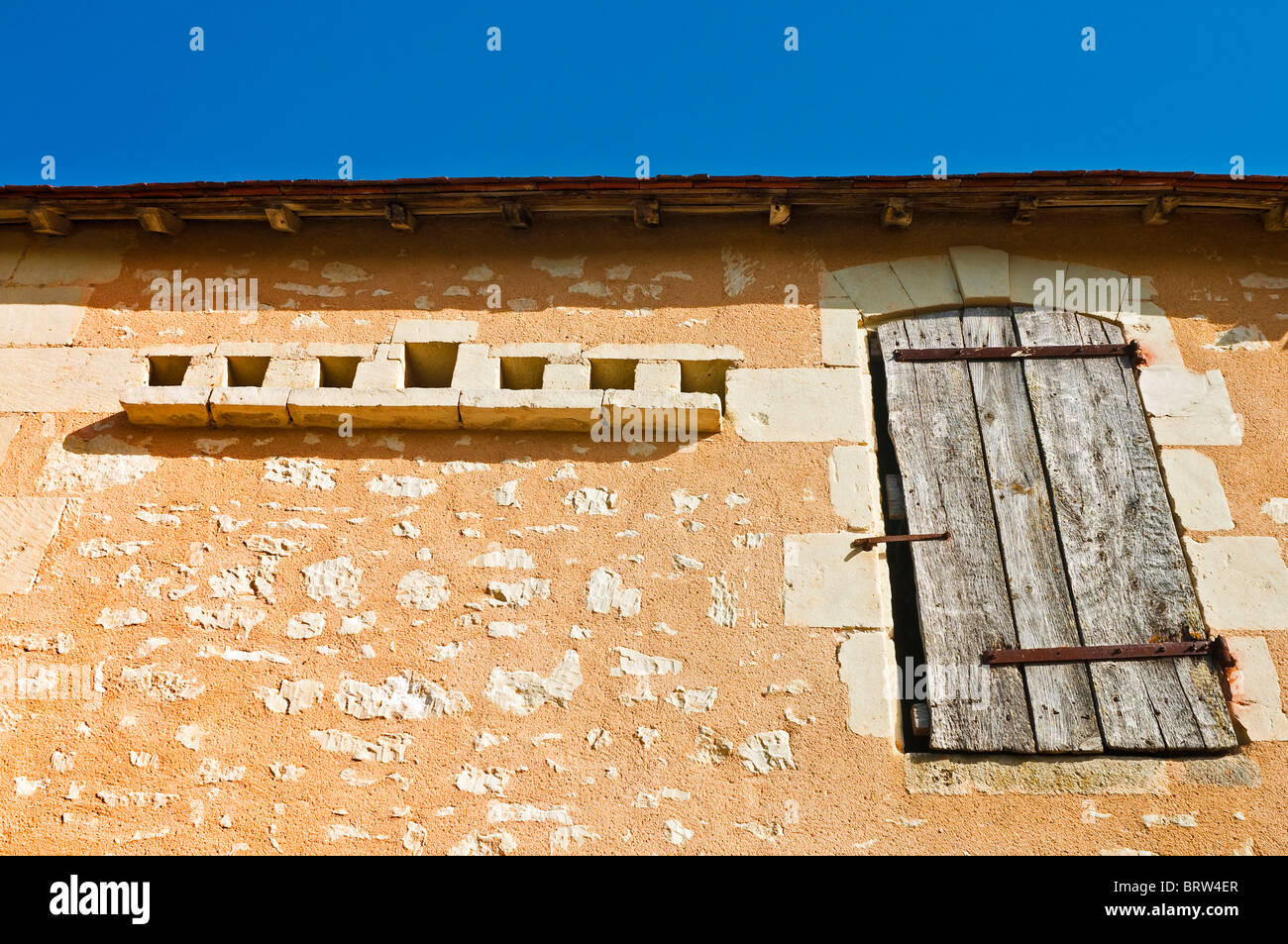 Traditional stone built farmhouse with pigeon loft holes in wall - France. Stock Photo