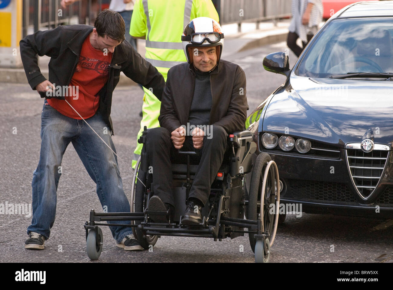 Rowan Atkinson, given a pull start on lawnmower powered wheelchair on set Johnny English Reborn