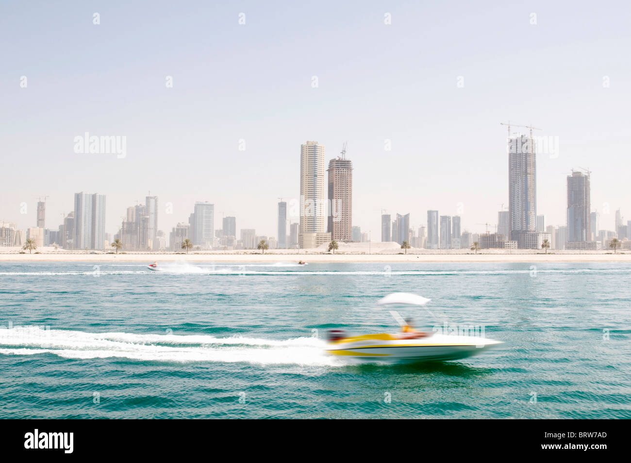 Skyline of Sharjah with speedboat, blurred, Dubai, United Arab Emirates Stock Photo