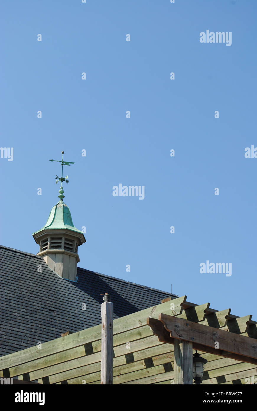 Blue sky with rooftop that has weather vane in yorktown hires stock