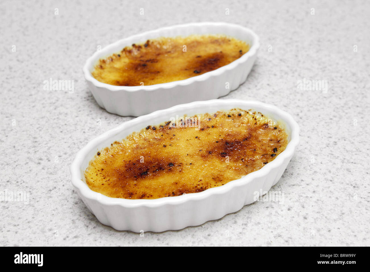 two ramekins with toasted creme brulee dessert Stock Photo Alamy