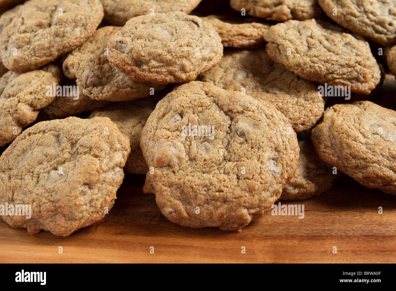 large stack of gluten free chocolate chip cookies on a cutting board Stock Photo