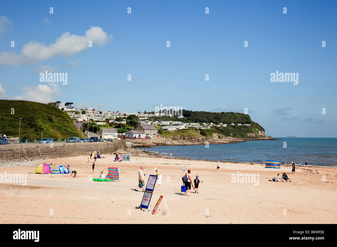Holidaymakers people on a quiet sandy beach in early summer. Benllech