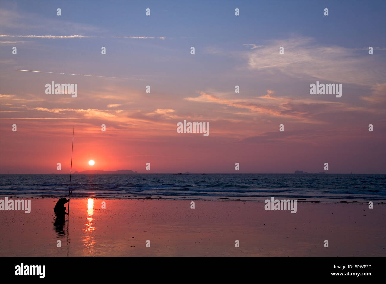 Fisherman fishing for Sea Bass on St Malo Plage, Brittany, France