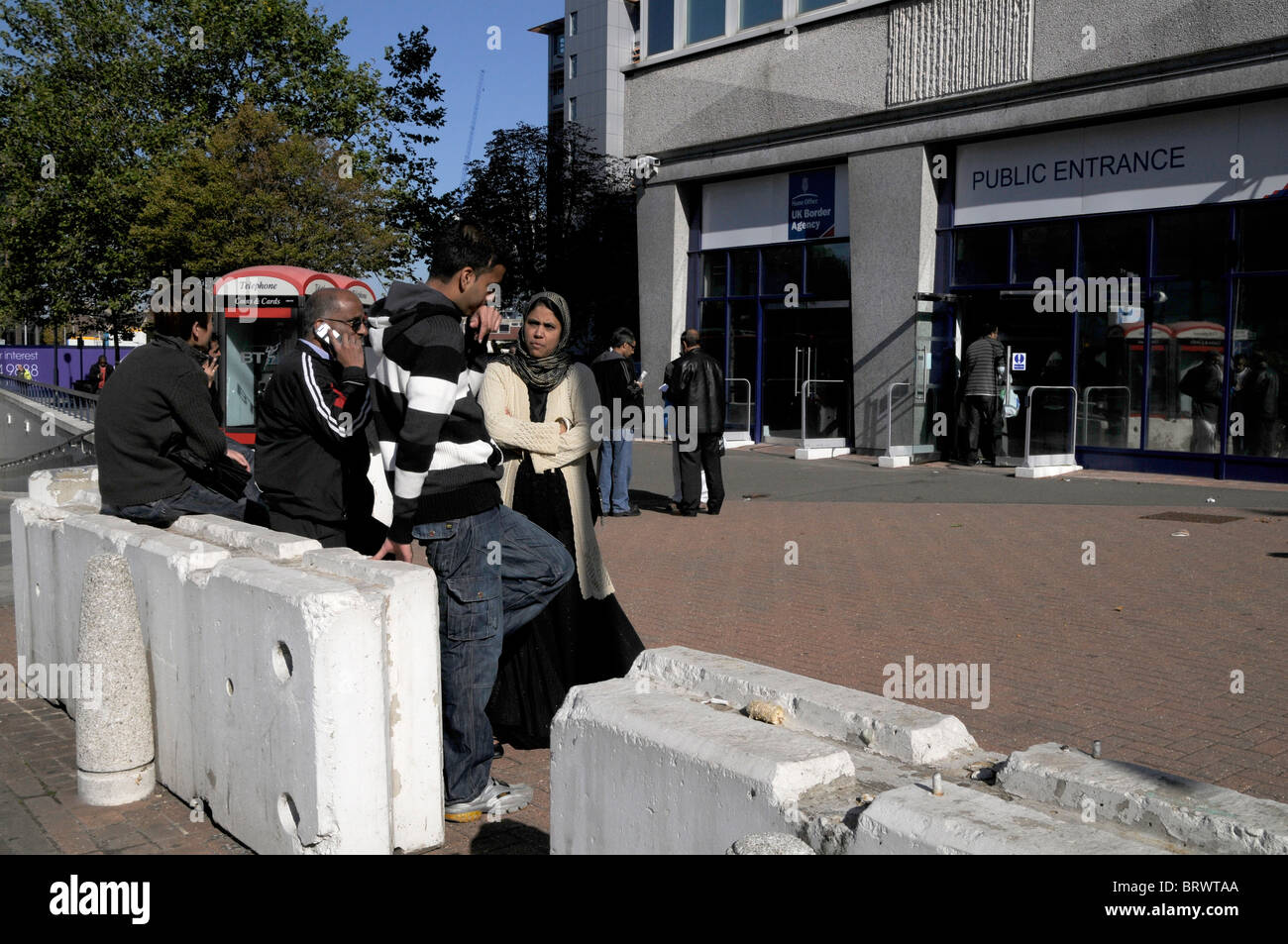 IMMIGRANTS WAITING FOR UK RESIDENCE APPROVAL OUTSIDE HOME OFFICE IN