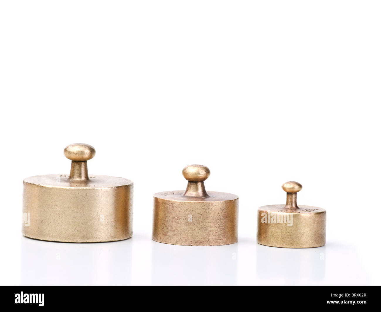 three older and wornout balance scale weights in different sizes