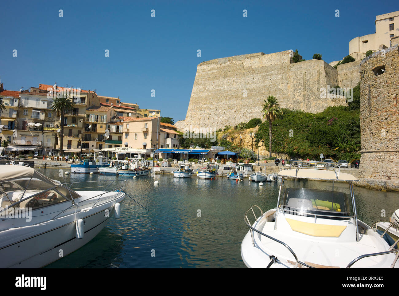 Yachts in the marina at Calvi, with the walls of the Citadels. Stock Photo