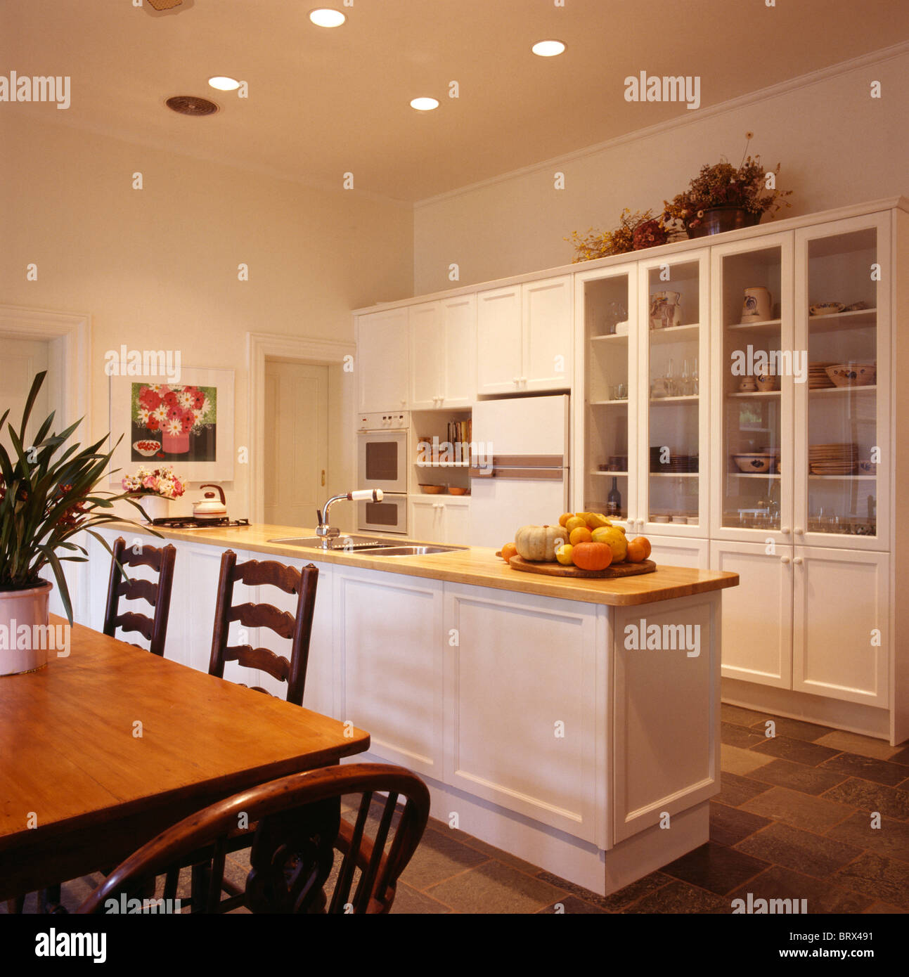 Antique chairs and wood table in large traditional cream kitchen