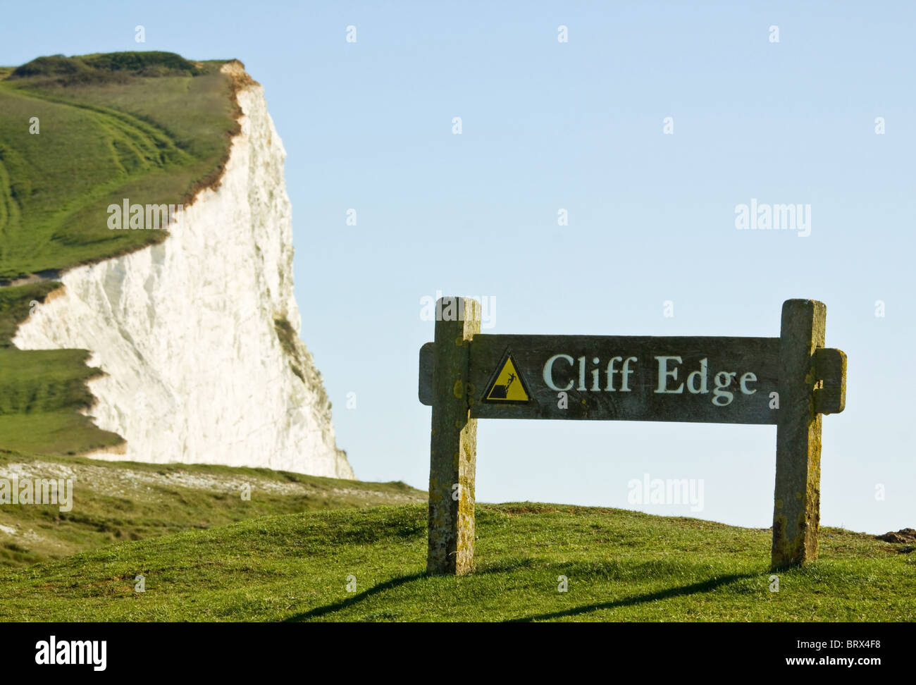 Sign Warning Cliff Edge with Chalk Downs in Background Stock Photo