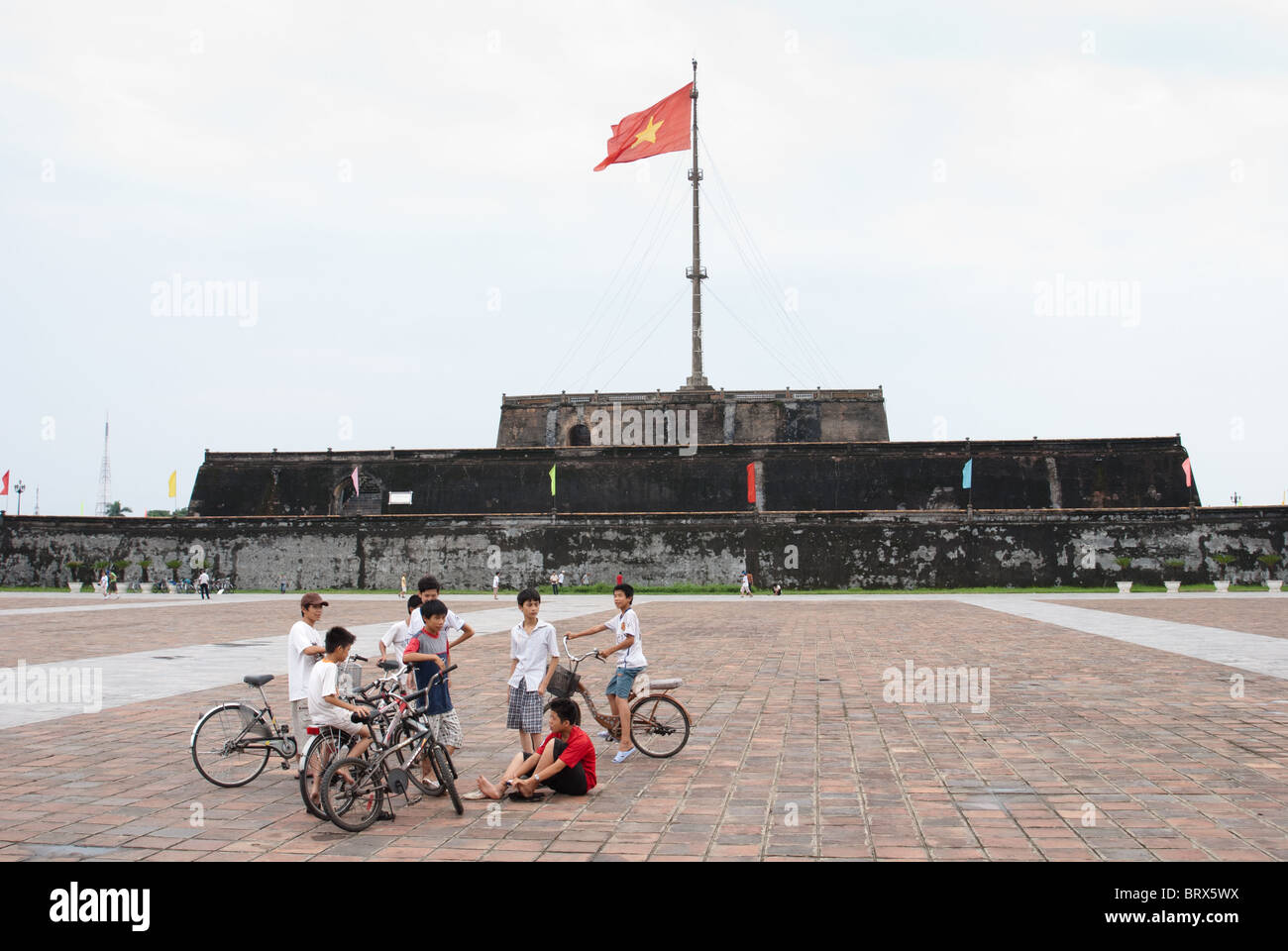 Boys in front of flag tower, Hue, Vietnam Stock Photo
