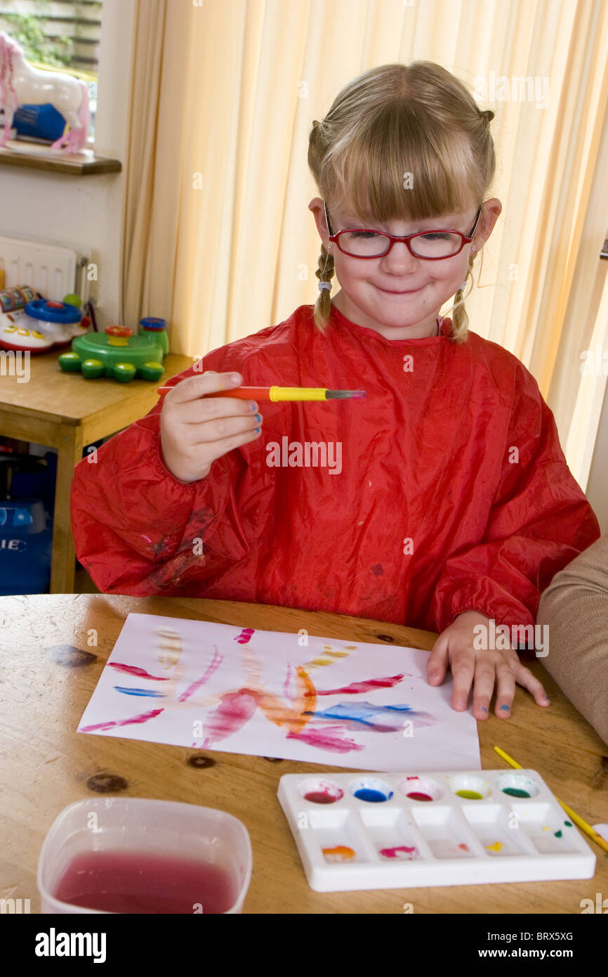 Child paint with watercolors at home wearing an apron Stock Photo Alamy