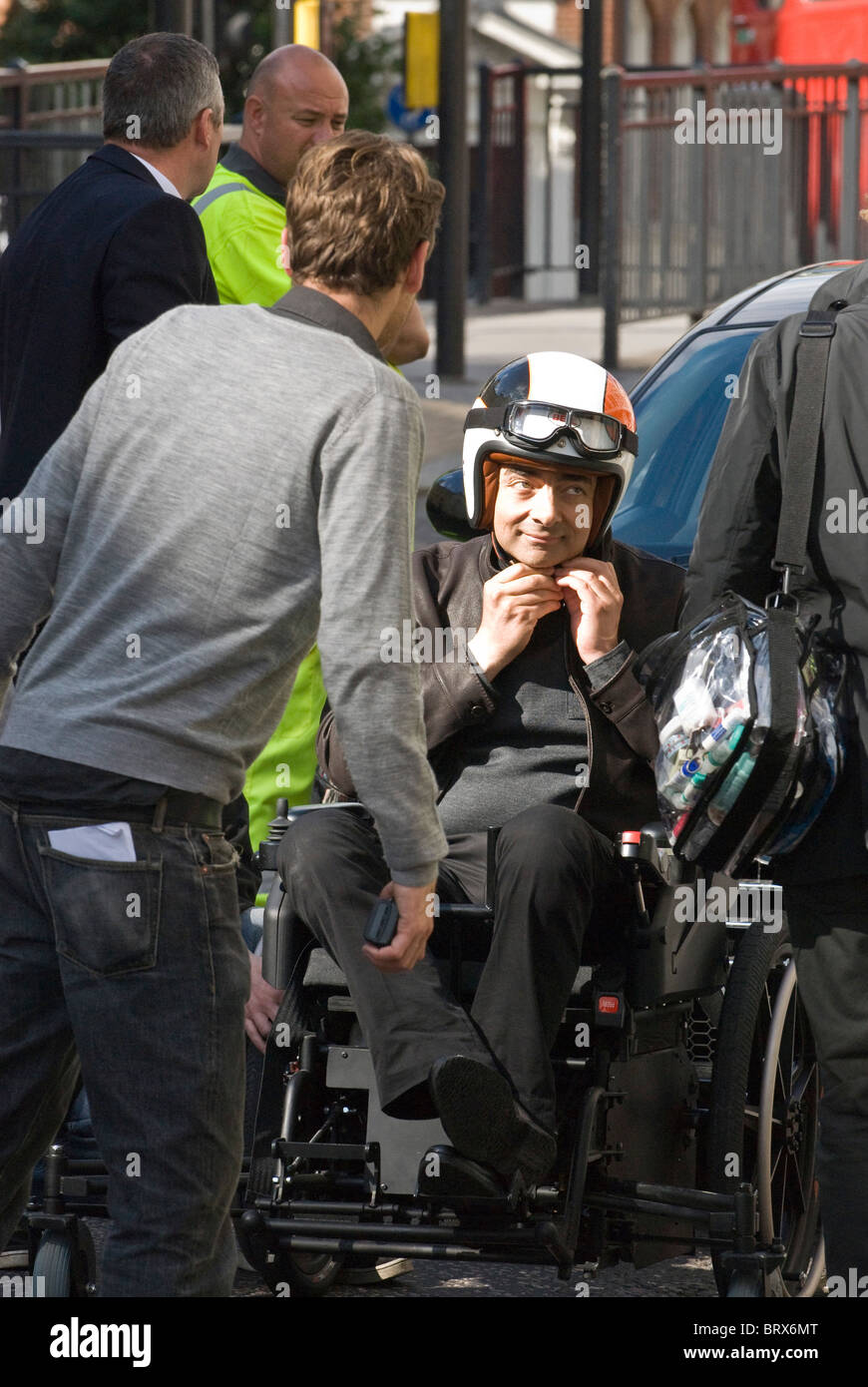 Rowan Atkinson, fastens crash helmet prepares for action  lawnmower powered wheelchair on set Johnny English Reborn 2 London UK Stock Photo