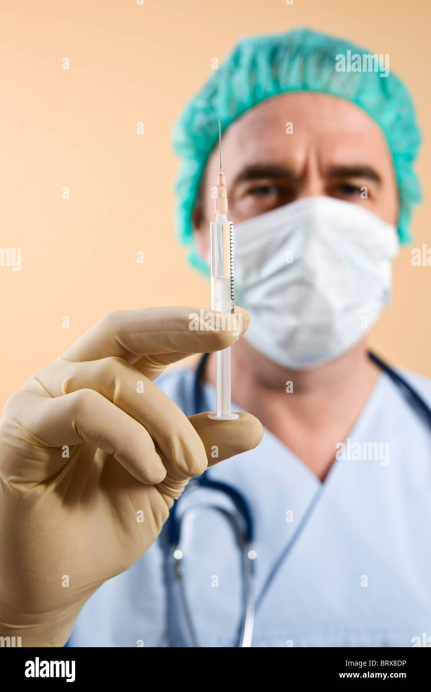 Surgeon holding a syringe Stock Photo Alamy