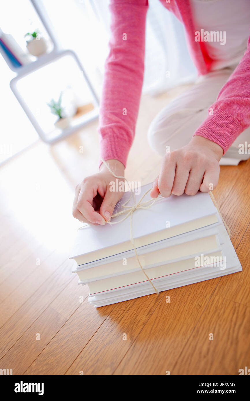 Close up of Woman Tying Books Together Stock Photo Alamy