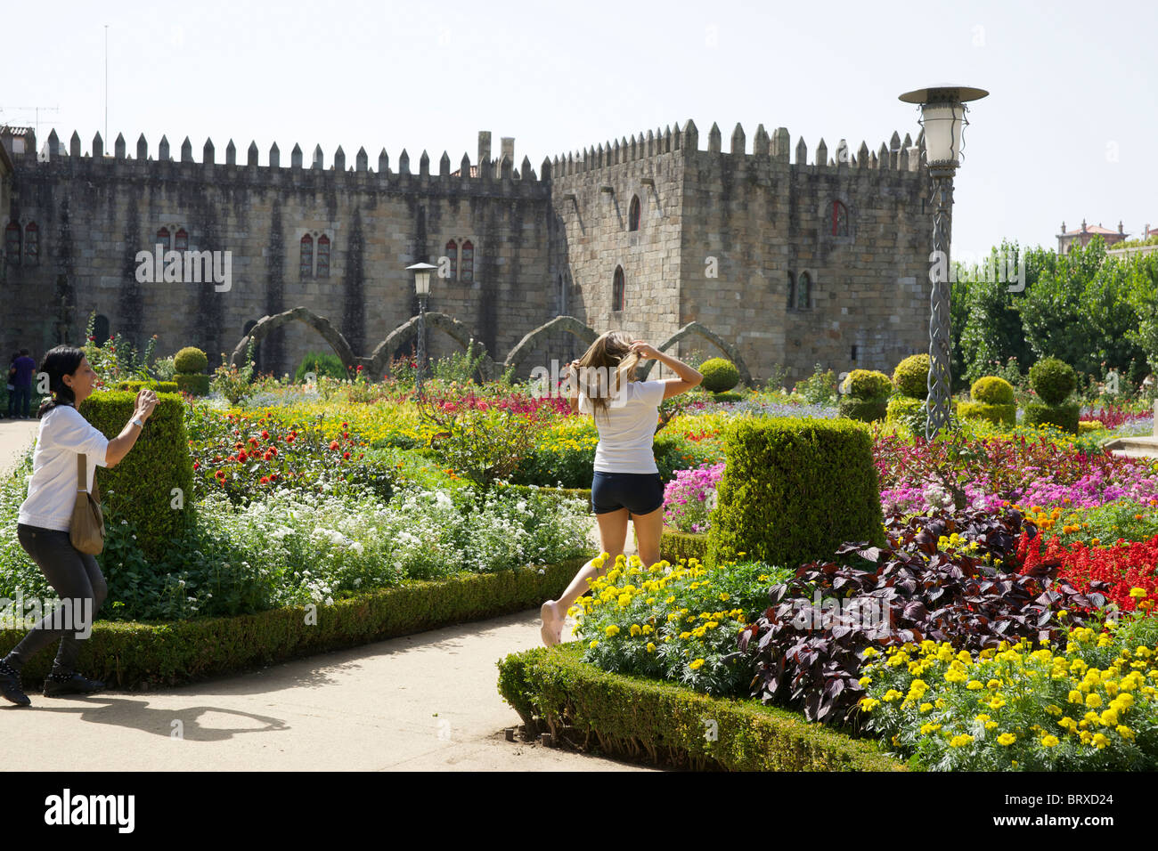 A girl taking a photo of another girl in the beautiful flower gardens in Braga, Portugal. Stock Photo