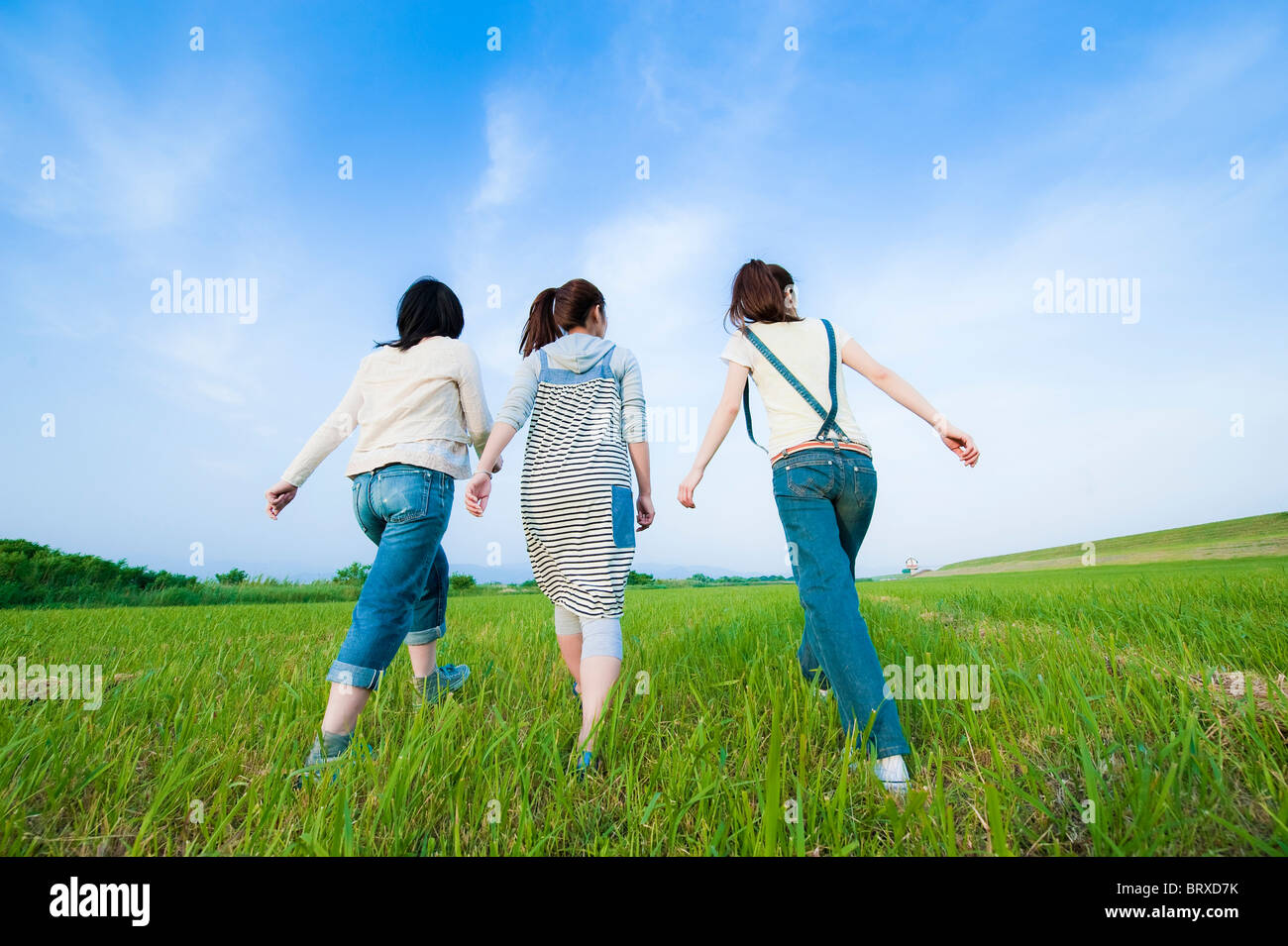 Three Young Women Walking in Field Stock Photo - Alamy