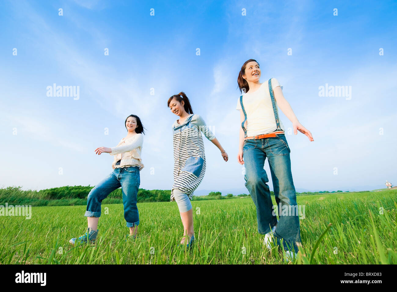 Three Young Women Walking in Field Stock Photo - Alamy