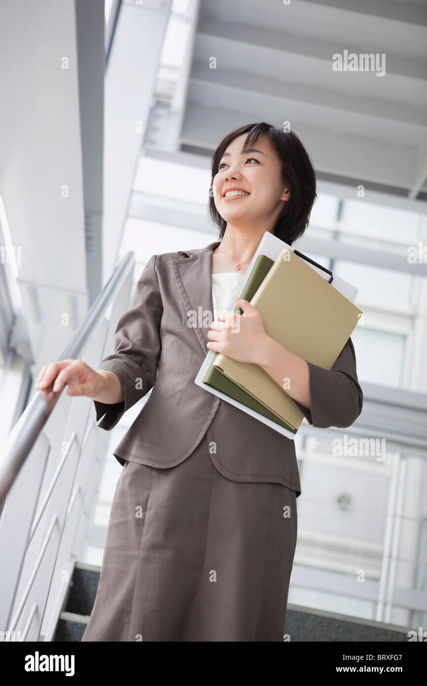 Businesswoman Walking Down Stairs Stock Photo - Alamy