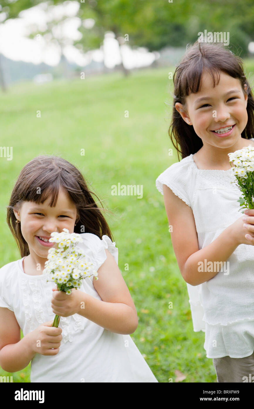 Two Girls Holding Bunch of Flowers Stock Photo