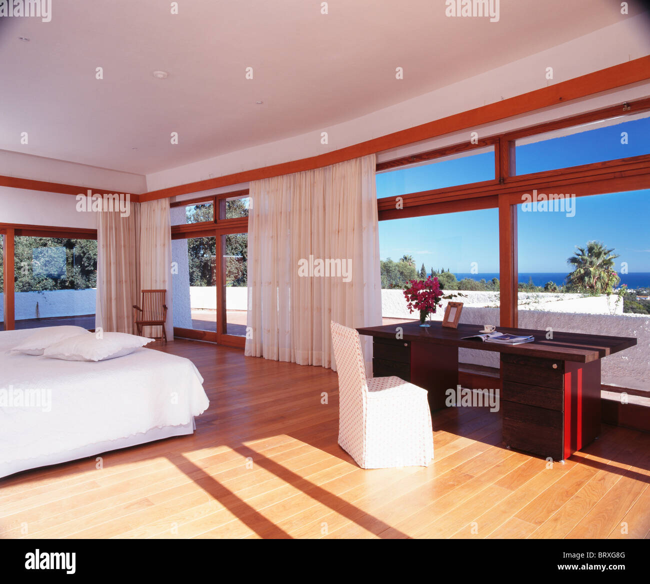 Wooden Flooring In Large Modern Spanish Bedroom With White