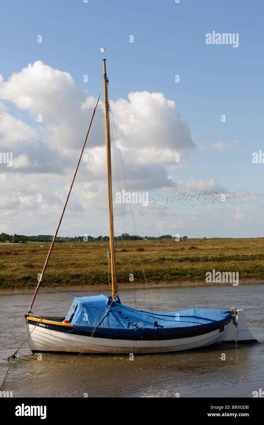 A boat moored in a creek at Blakeney on the North Norfolk coast, England Stock Photo