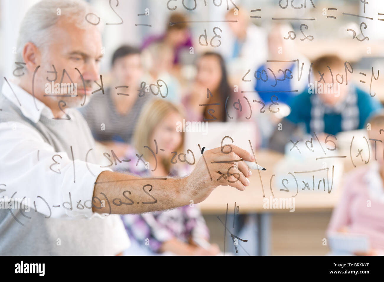 Math lesson at high school - students with professor in classroom Stock Photo