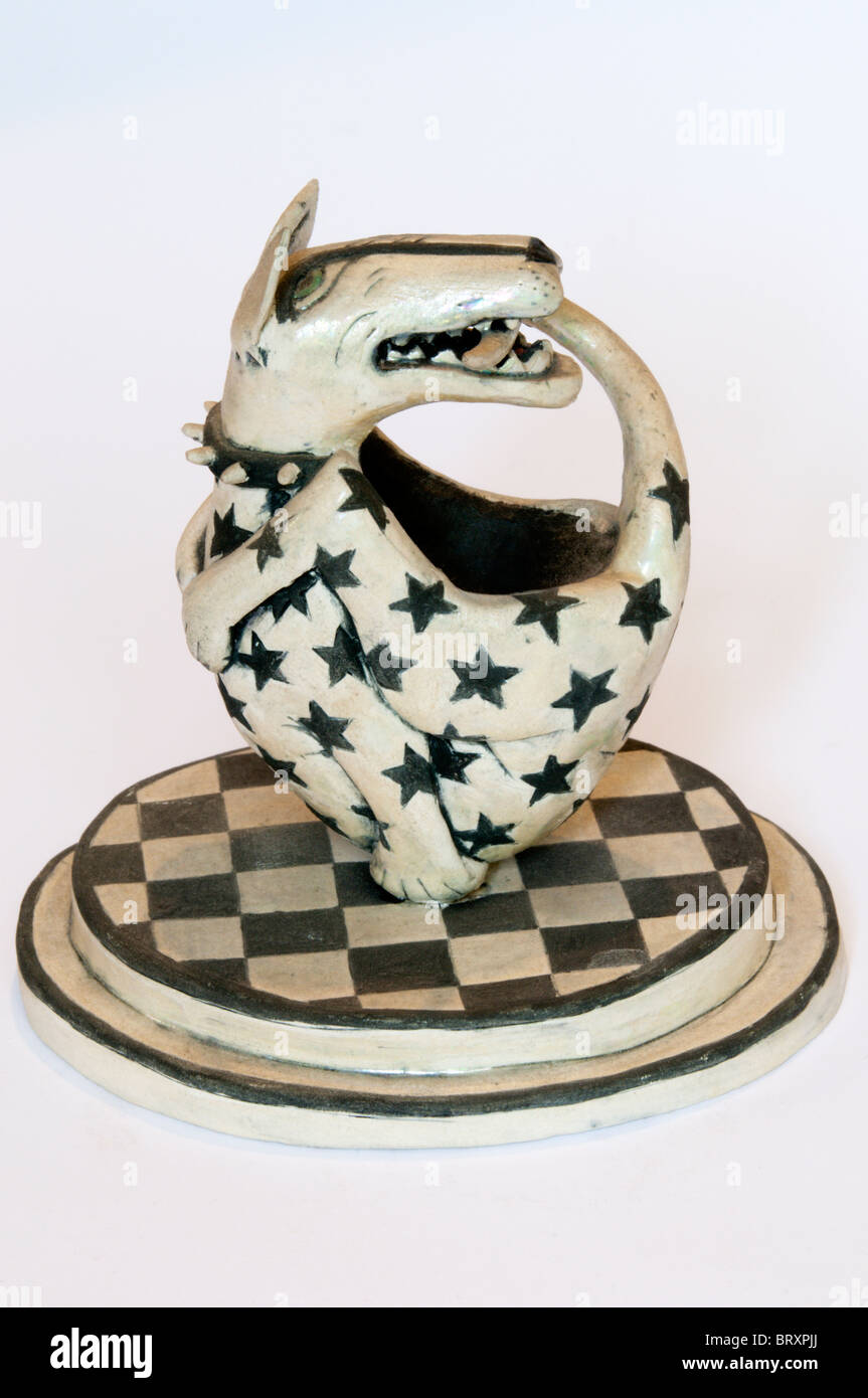 A ceramic figure of a dog biting its own tail by Eleanor Bartleman. Stock Photo