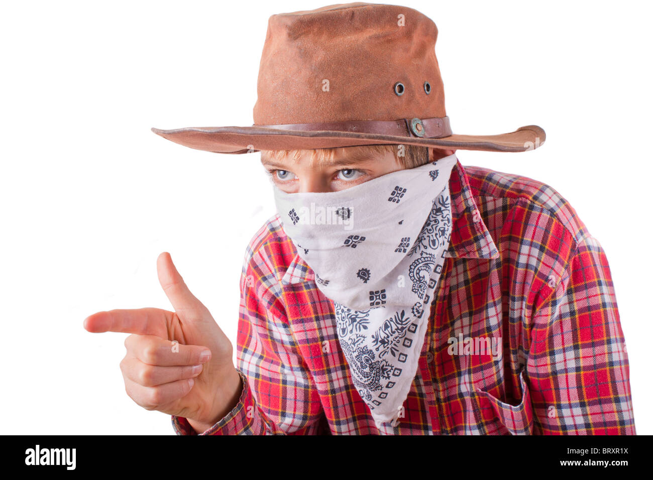 boy dressed up as a bandit for halloween holds his hand like a gun isolated on white Stock Photo