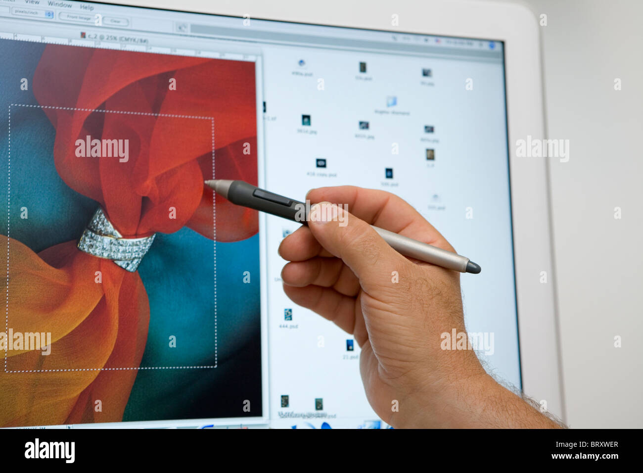 Graphic designer showing detail of graphic design displayed on computer