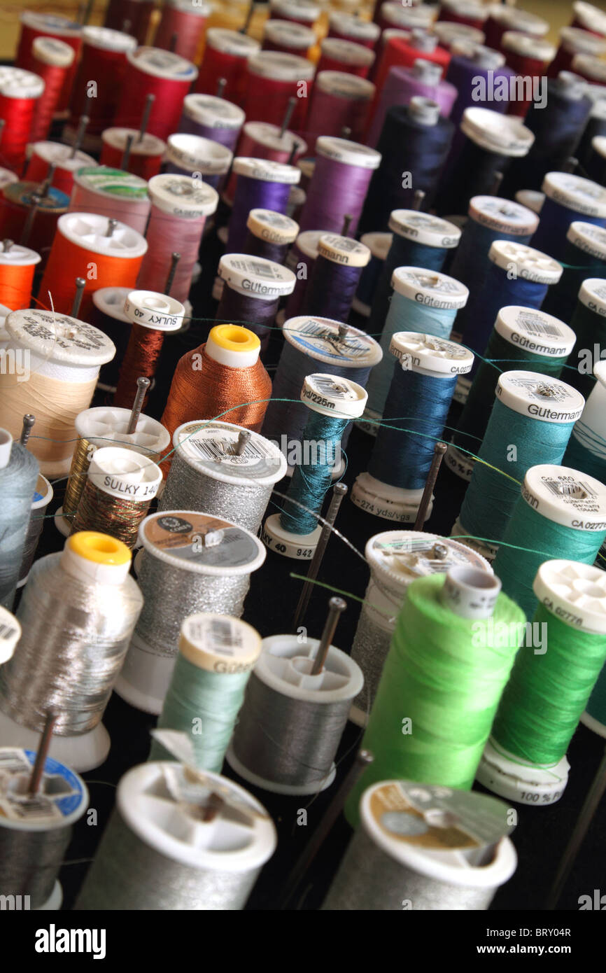 Colorful spools of silk thread in seamstress shop Stock Photo