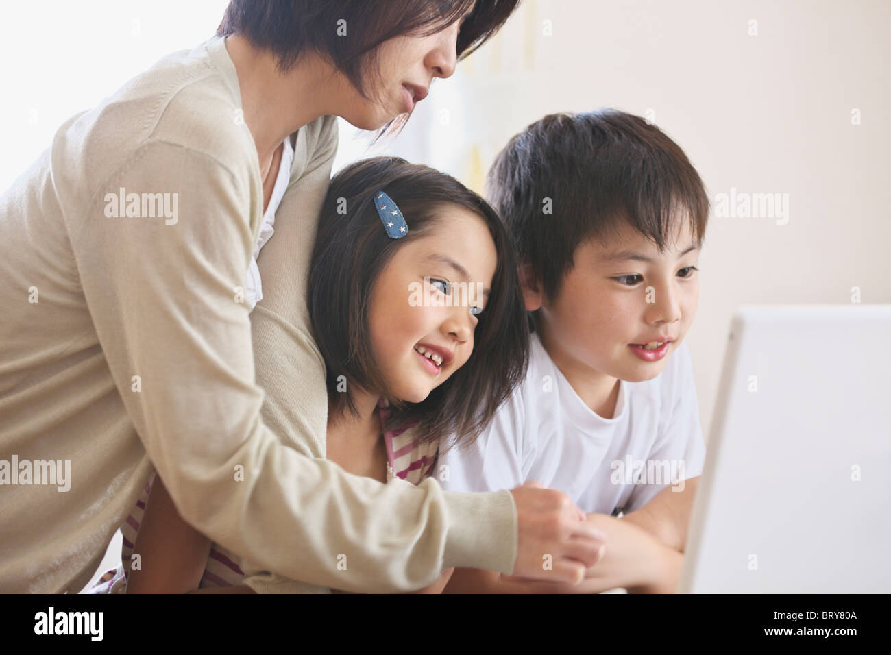 Mother and children using laptop Stock Photo - Alamy