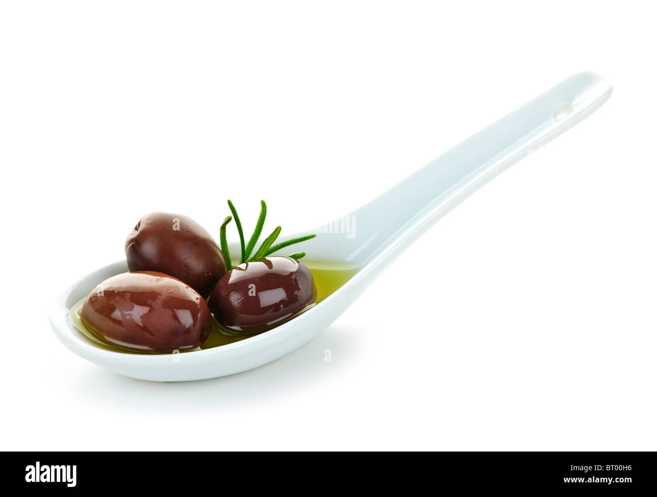Kalamata olives in olive oil and herbs on spoon Stock Photo